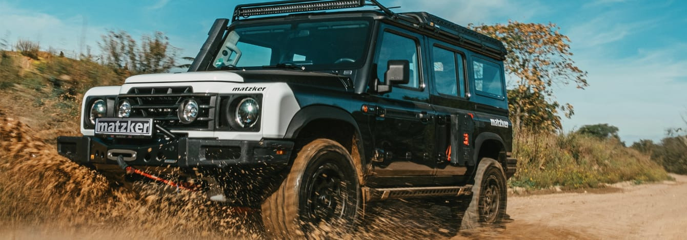 Ineos Grenadier mit Sonderausstattung duch Matsch fahrend