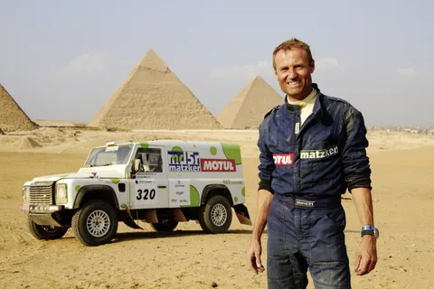 Ein Rallyefahrer und ein Matzker-Fahrzeug vor den Pyramiden.